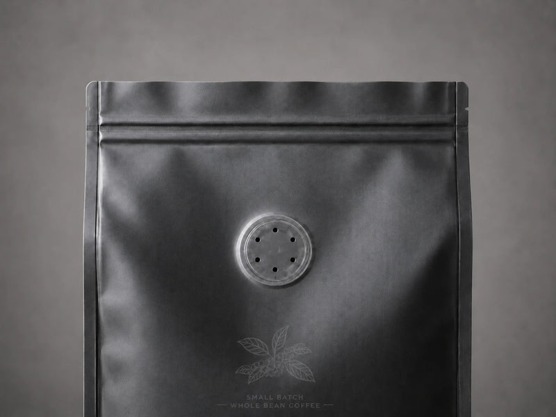 Makroaufnahme eines Aromaventils auf einem matten, dunklen Kaffeebeutel
