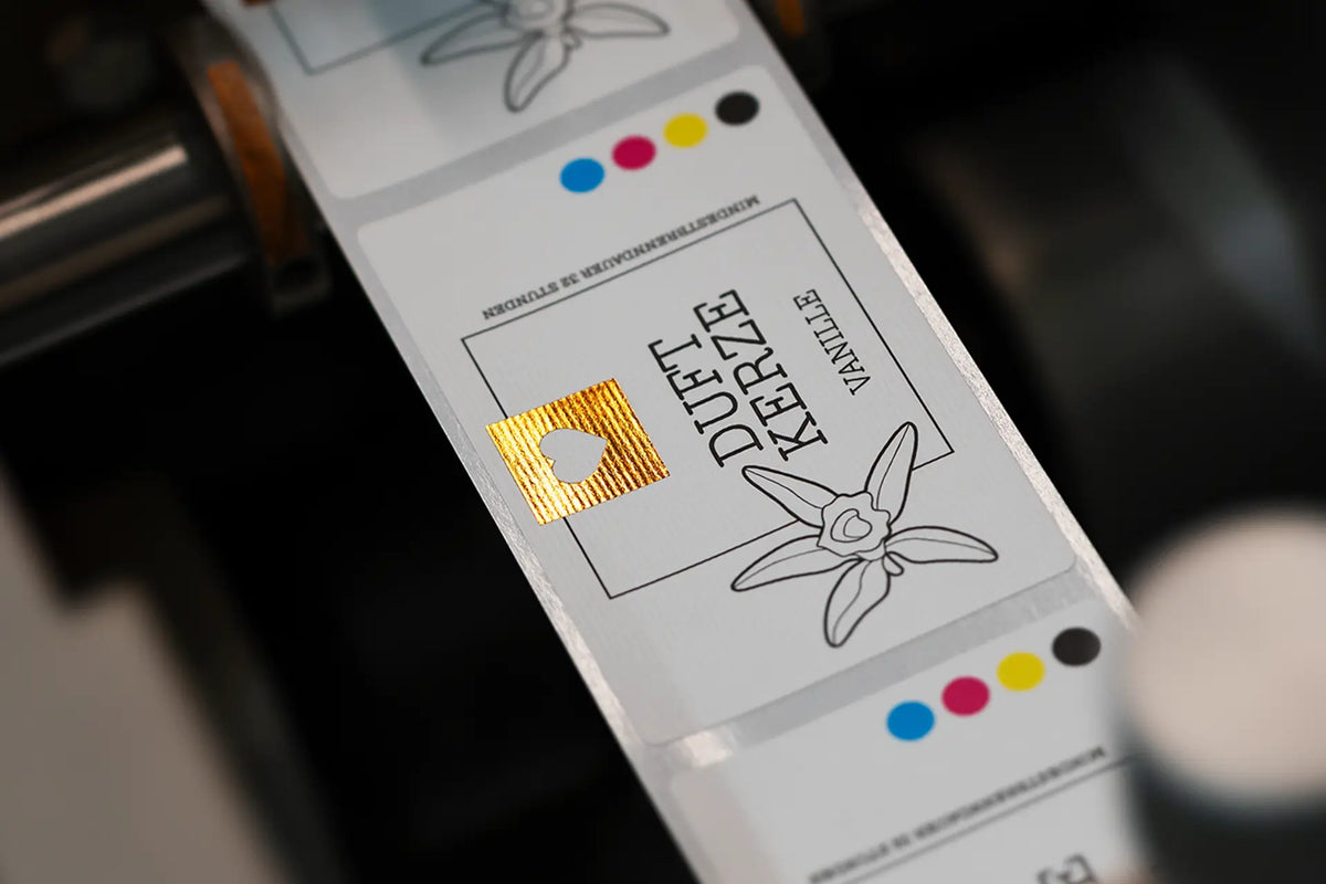 Papier-Etiketten auf der Rolle, darauf ein Quadrat in goldener Heißfolie mit ausgespartem Herz